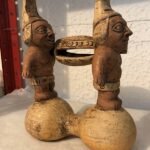 2 INDIGENAS ENCIMA DE PIEDRAS CARGANDO UN ATAUD