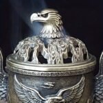 Un majestuoso portaincienso de águila que presenta un tapa con un patrón de nube hueca y un cuerpo adornado con un águila en vuelo en relieve. Este portaincienso de aleación, diseñado con tres patas, simboliza la libertad e independencia, así como la fuerza y el coraje. - Image 5