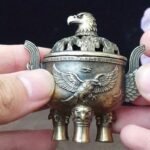 Un majestuoso portaincienso de águila que presenta un tapa con un patrón de nube hueca y un cuerpo adornado con un águila en vuelo en relieve. Este portaincienso de aleación, diseñado con tres patas, simboliza la libertad e independencia, así como la fuerza y el coraje. - Image 9